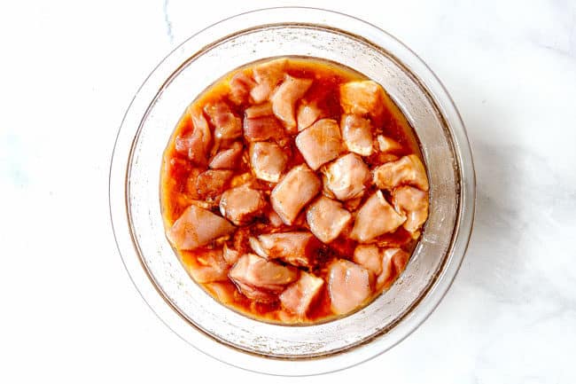 showing how to make yakitori by adding chicken to yakitori sauce to marinate