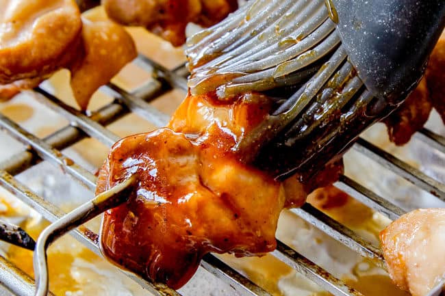 showing how to make yakitori by basting chicken with yakitori sauce