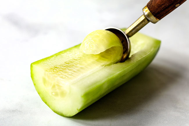 showing how to make Tzatziki by seeding cucumber