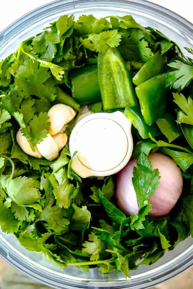 showing how to make grilled pork tenderloin by adding chimichurri ingredients to blender