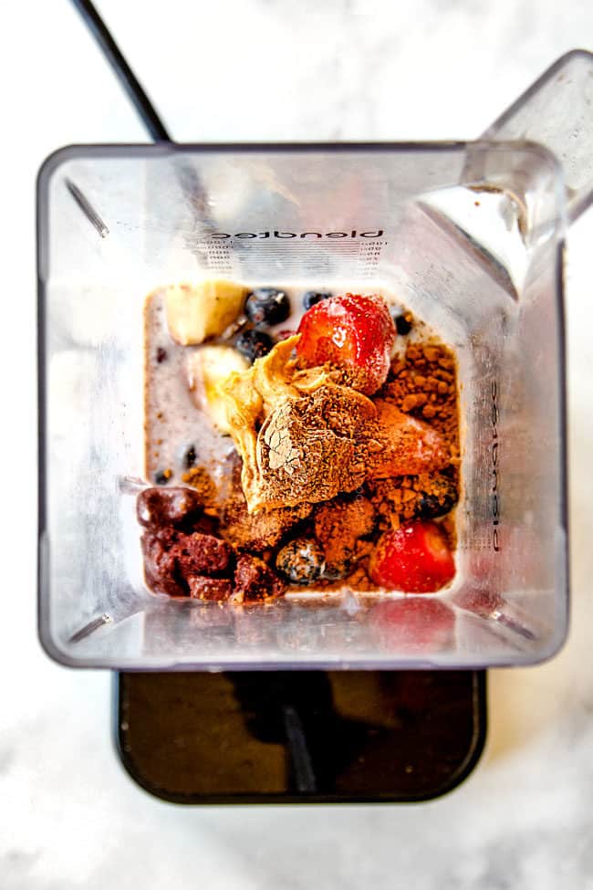 showing how to make acai bowls by adding bananas, strawberries, blueberries, peanut butter, unsweetened cocoa and milk to blender