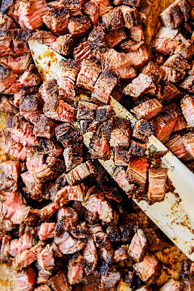 showing how to make carne asada tacos by chopping steak into small pieces