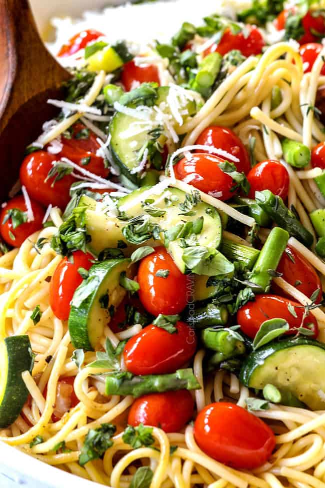 showing how to make lemon chicken pasta by tossing chicken and vegetables with passata
