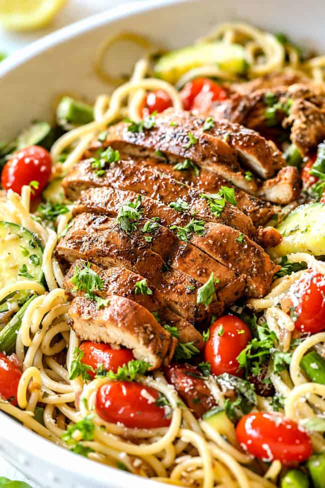 side view of lemon parmesan chicken pasta with asparagus and tomatoes