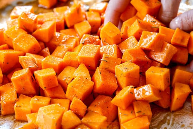 showing how to roast butternut squash by tossing with olive oil and seasonings