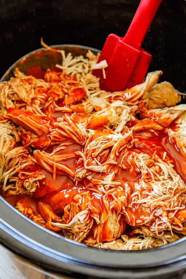 crockpot buffalo chicken by stirring buffalo hot sauce into chicken