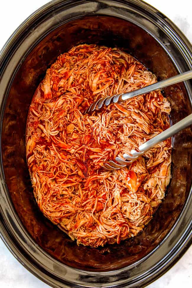 showing how to make healthy crockpot buffalo chicken recipe by serving with tongs