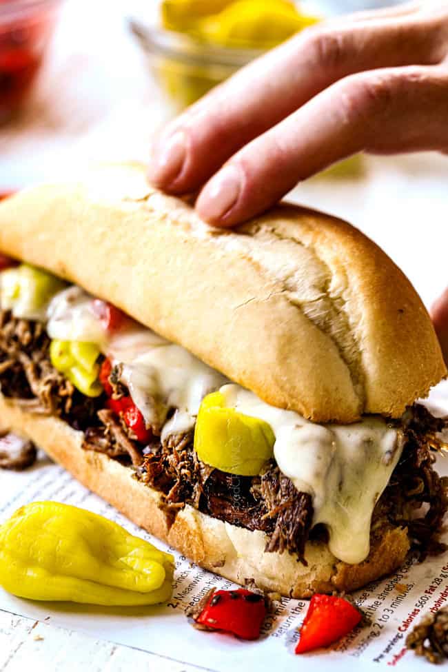a hand picking up an Italian Beef Sandwich