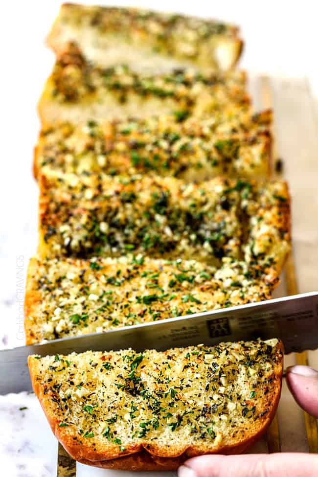 slicing easy garlic bread on a cutting board