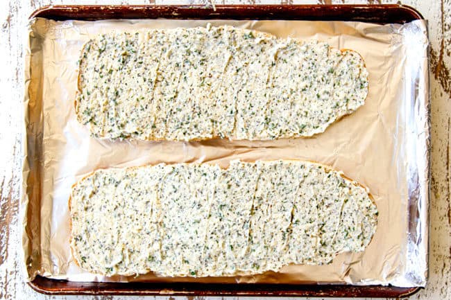showing how to make homemade garlic bread by spreading garlic butter spread on french bread in an even layer