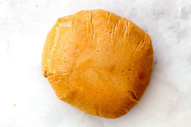 showing how to make peanut butter balls by wrapping in plastic wrap and forming a ball