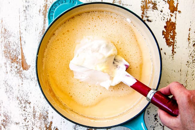 showing how to make queso blanco (white queso dip) by whisking sour cream into evaporated milk