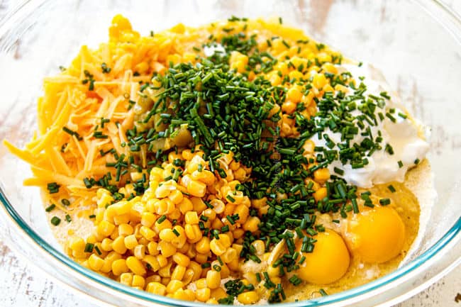 showing how to make corn casserole recipe by mixing creamed corn, corn kernel, sour cream, eggs and butter together in a glass bowl