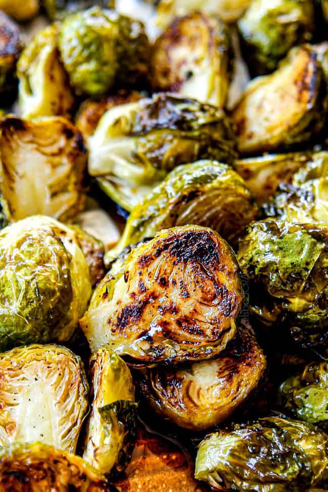 tossing Baked Brussels Sprouts on a baking sheet with salt and pepper