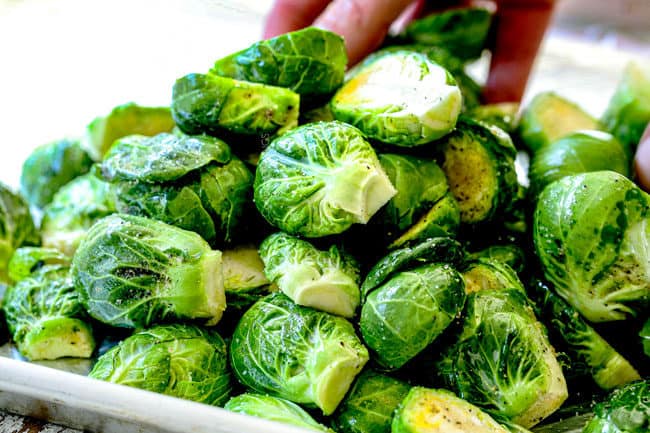showing how to make Brussels Sprouts recipe in oven by tossing sprouts with seasonings