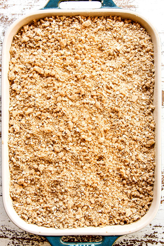 showing how to make easy apple crisp recipe by adding apple crisp topping to apples