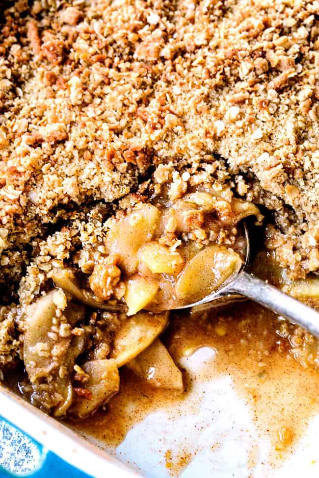 up close digging into a 9x13 of best apple crisp recipe with oatmeal topping