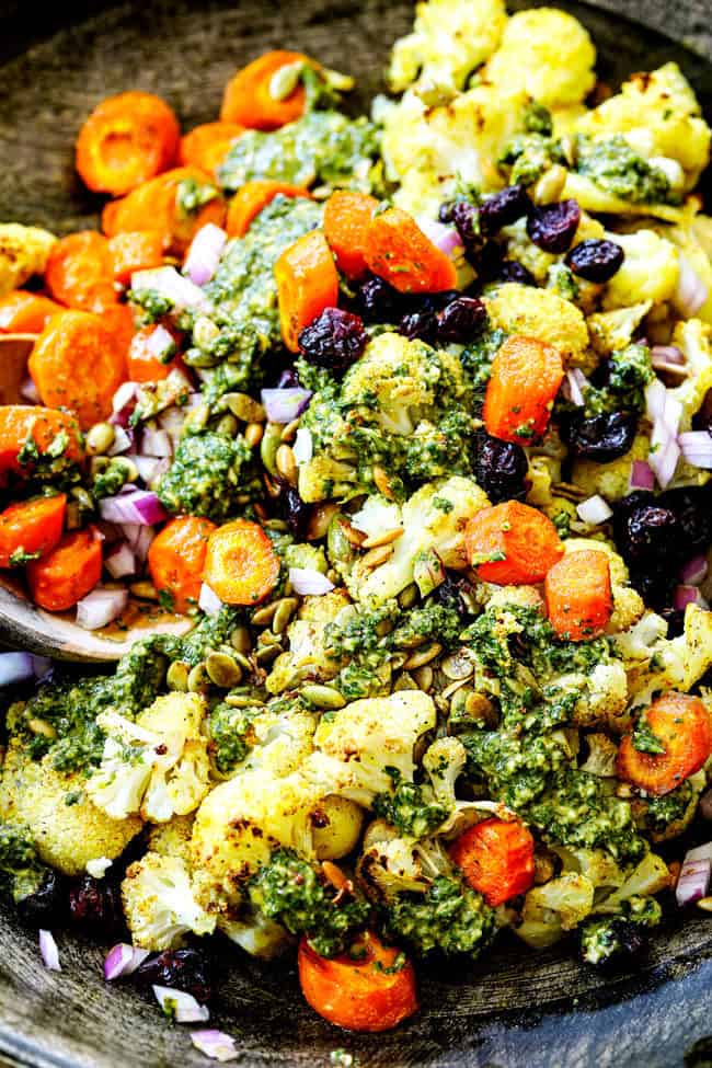 showing how to make cauliflower salad tossing cauliflower with dressing in a large bowl