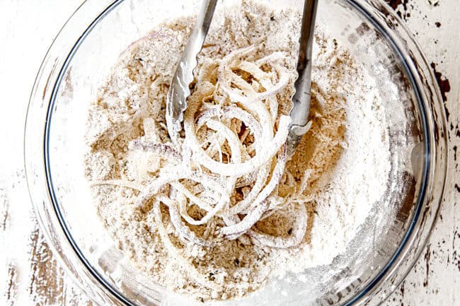 showing how to make BBQ Burger recipe with fried onion strings by mixing onions with flour and panko before frying