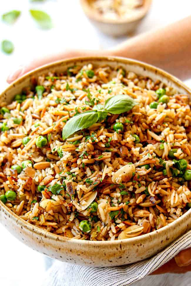two hands holding easy rice pilaf recipe in a bowl