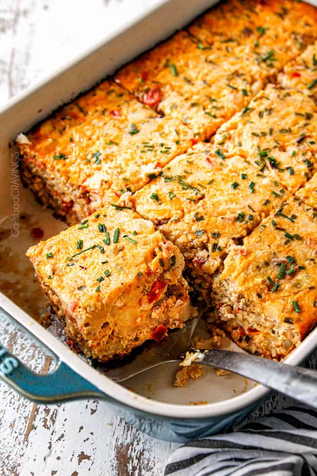 a pan of overnight breakfast casserole recipe with a spatula picking up a slice