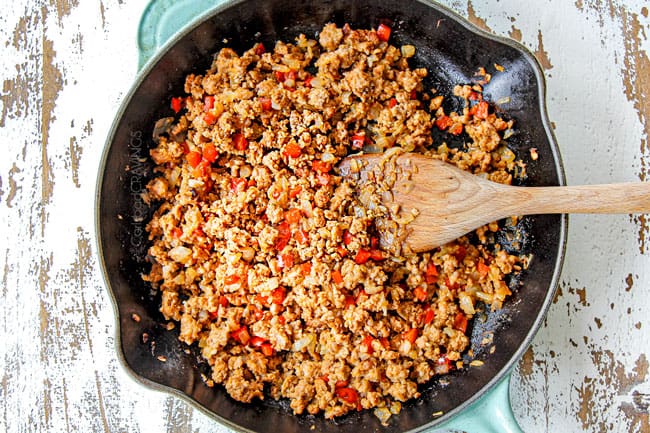 showing how to make breakfast casserole by cooking sausage, onions and bell peppers