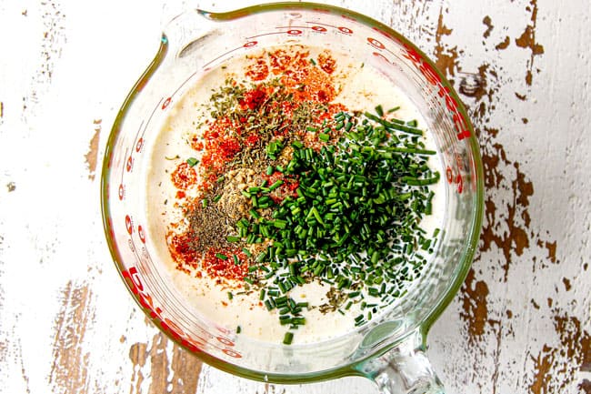 showing how to make easy breakfast casserole adding eggs, heavy cream, chives and seasonings together