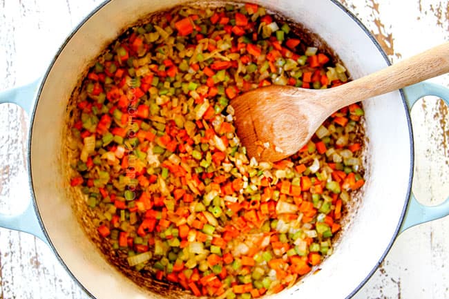 showing how to make braised short ribs by sauteeing carrots, onions and celery in a Dutch oven