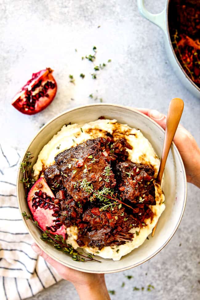 showing how to serve beef short ribs recipe by two hands holding a bowl of short ribs