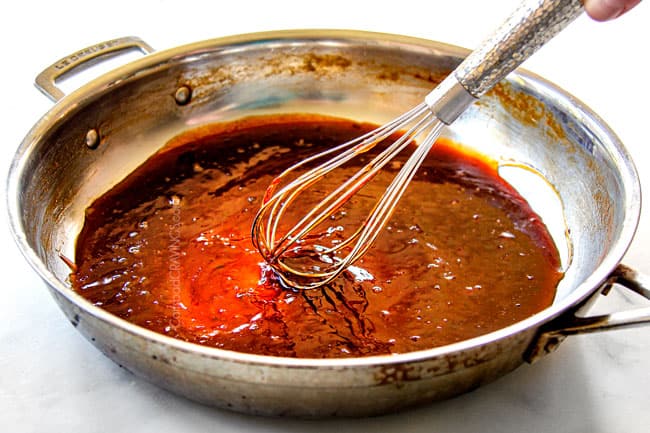 showing how to make cocktail meatball sauce by simmering until thickened in a stainless steal skillet