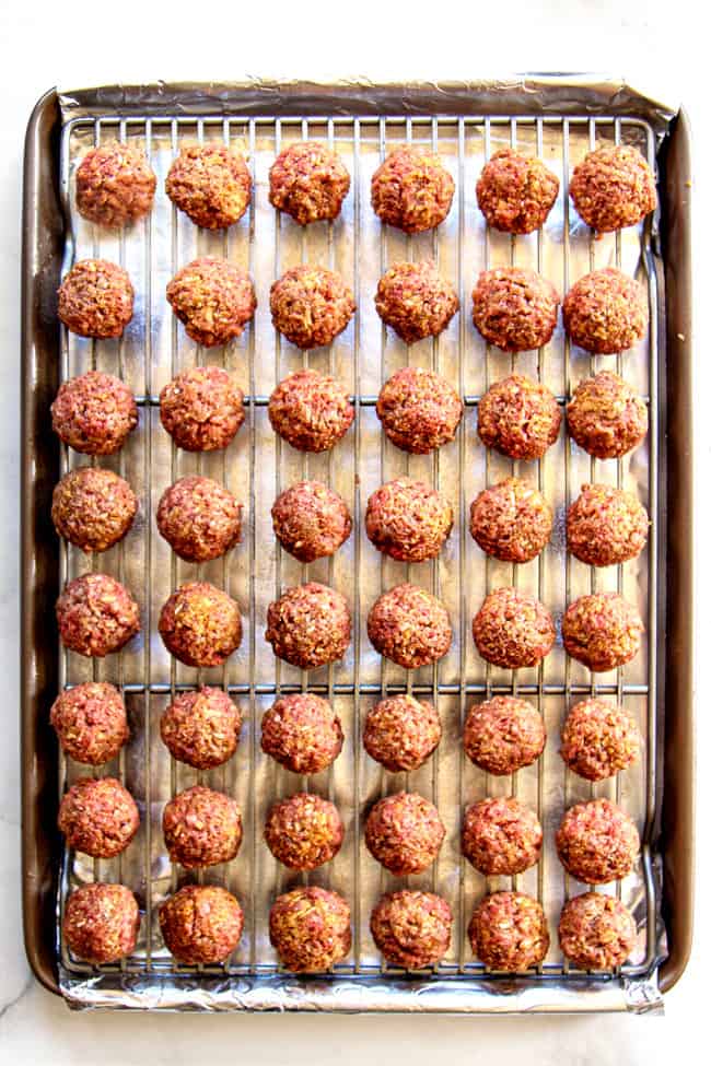 top view showing how to make easy cocktail meatball recipe by lining unbaked meatballs on a baking rack so they aren't touching