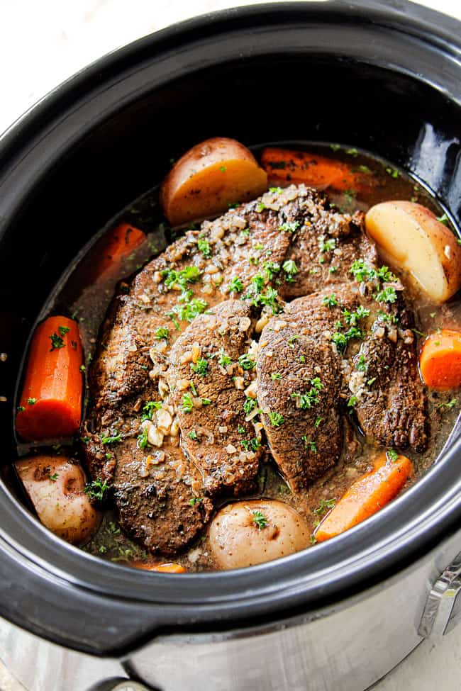 showing how to cook a roast in a crock pot by cooking chuck roast until tender