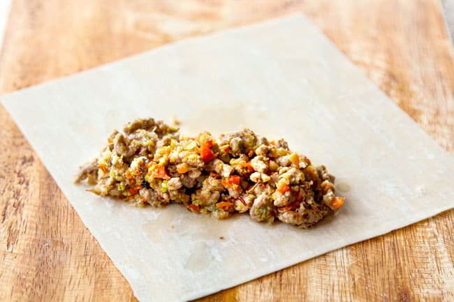 showing how to make egg rolls by adding filling to bottom third of egg roll wrapper