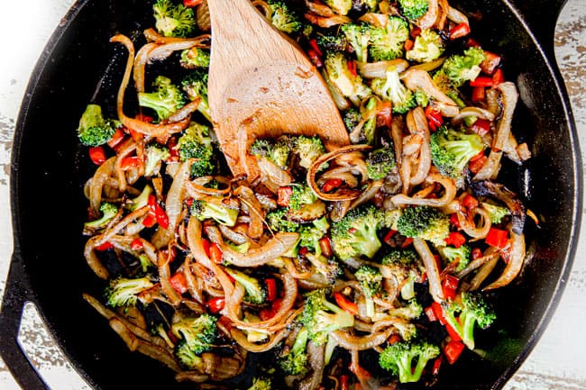 showing how to make frittata recipe by combining cooked vegetables with sauteed onions in a cast iron skillet