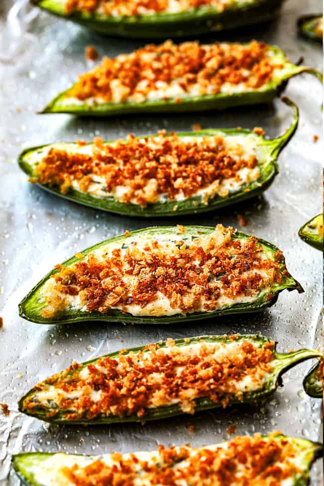 showing how to make homemade jalapeno popper recipe by lining poppers up in a row on a baking sheet