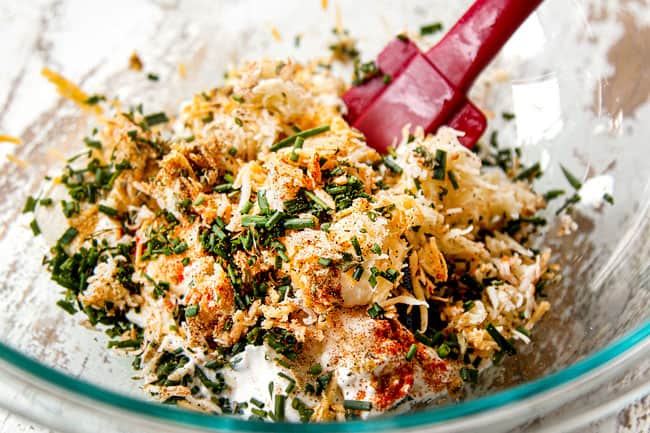 showing how to make jalapeno poppers by making cream cheese filling by mixing cream cheese, sour cream, cheddar cheese and spices in a bowl