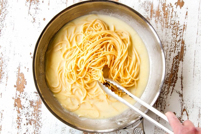 showing how to make Cacio e Pepe by adding pasta to emulsified butter cheese sauce