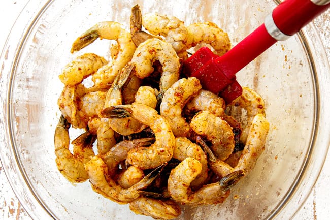 showing how to make Cajun shrimp pasta by marinating shrimp with olive oil, lime juice and Cajun seasoning