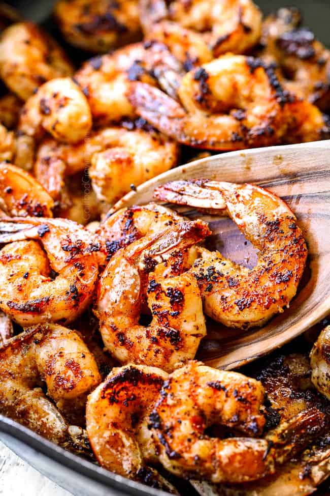 showing how to make Cajun shrimp pasta by cooking shrimp with Cajun seasoning in a skillet