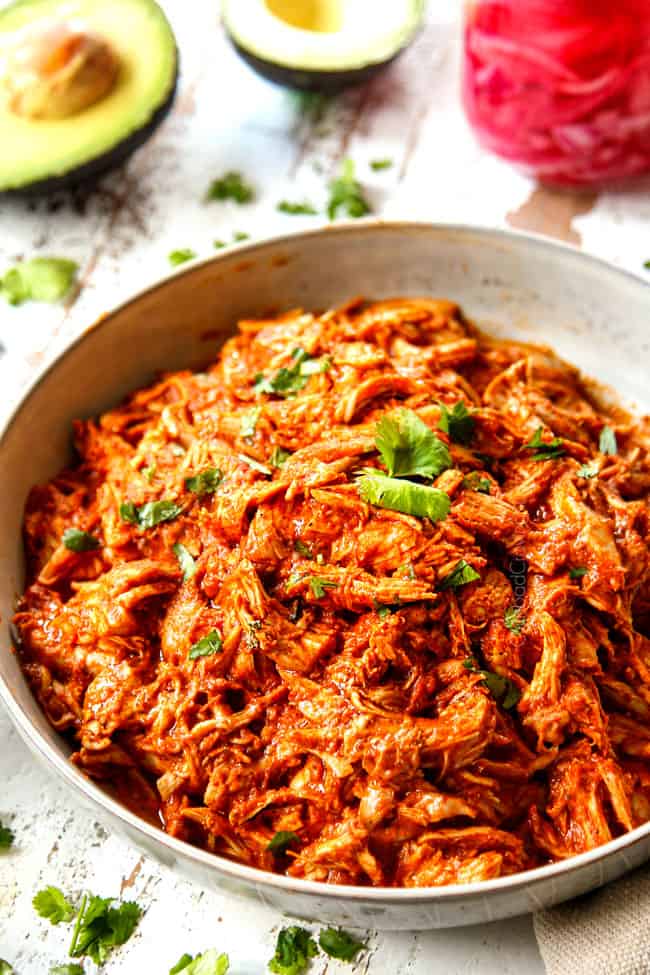 up close of slow cooker chicken tinga recipe in a bowl garnished with cilantro