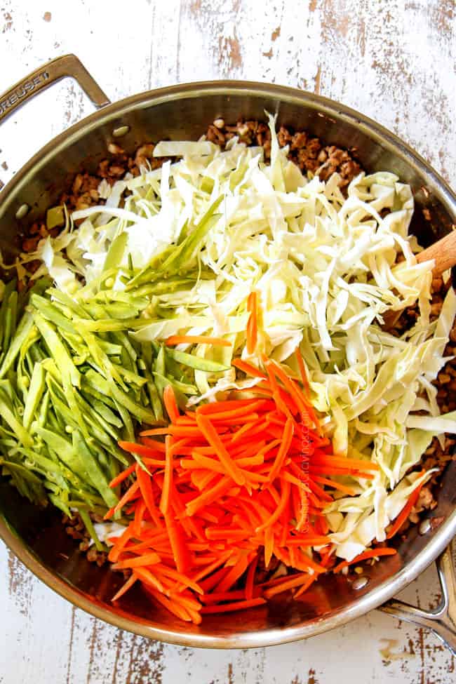 showing how to make Egg Roll in a Bowl by adding cabbage, carrots, snow peas to ground pork