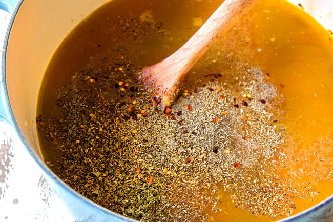 showing how to make Italian Meatball Soup by adding chicken broth, parsley, basil, oregano to soup