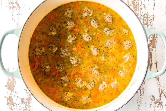 showing how to make Italian Meatball Soup by adding meatballs to soup to cook in the broth