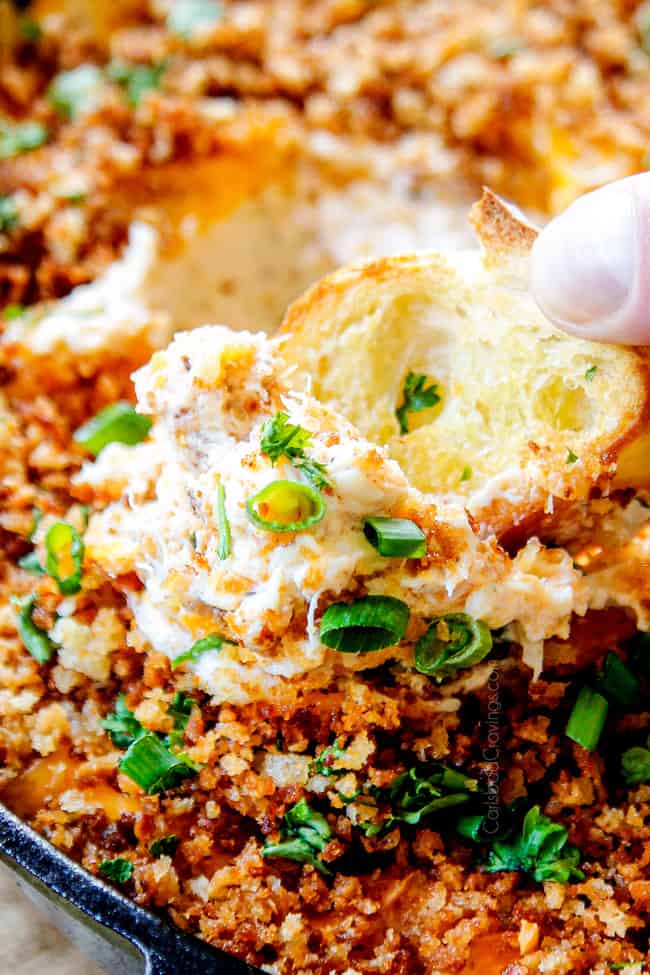up close of easy crab dip dipped into with a cracker
