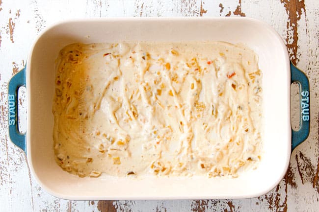 showing how to make easy chicken enchilada casserole recipe by layering a 9x13 pan with enchilada sauce