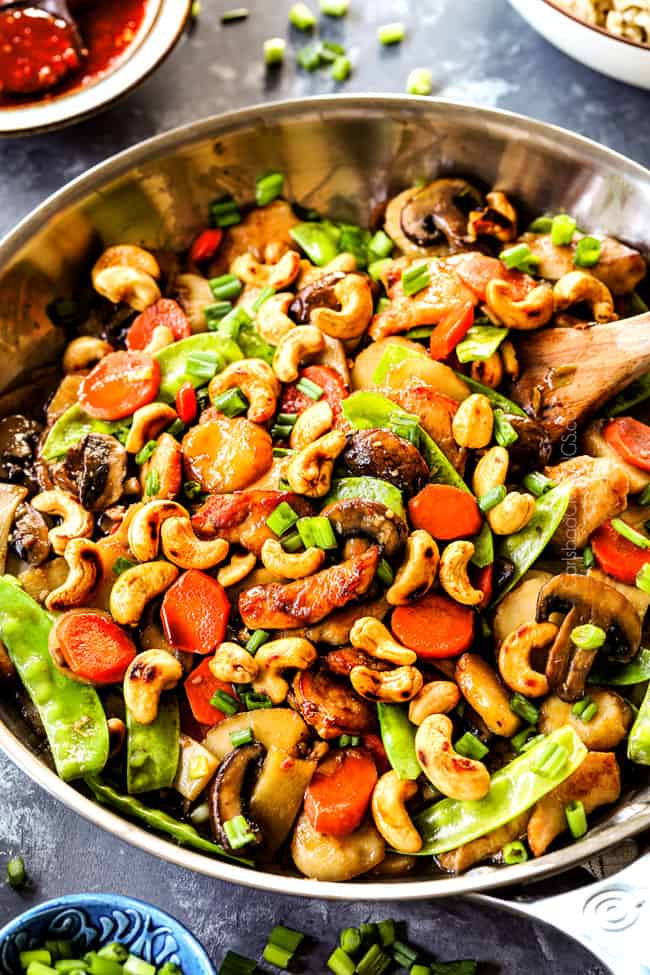 showing how to make authentic Moo Goo Gai Pan recipe by stir frying thinly sliced chicken, mushrooms, carrots, snow peas, water chestnuts and bamboo shoots together