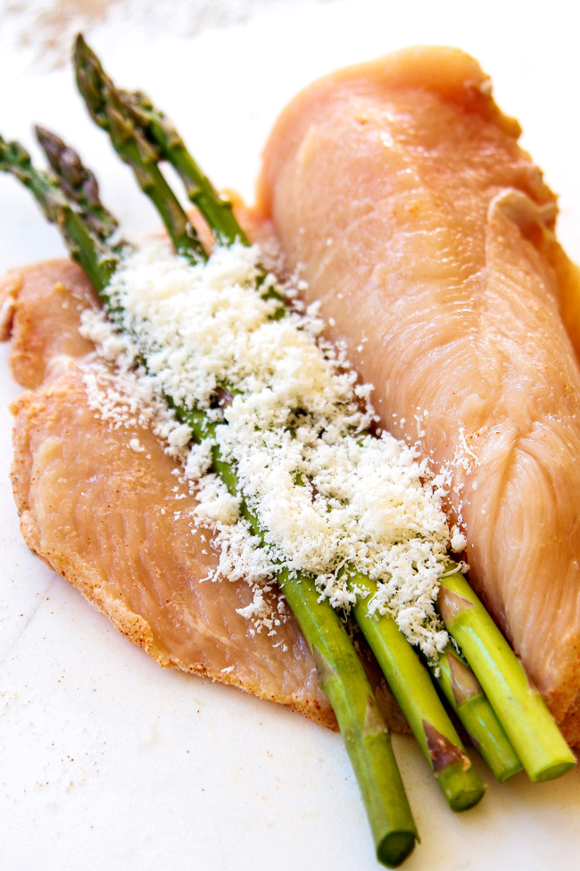showing how to make chicken piccata recipe by adding Parmesan and asparagus to chicken
