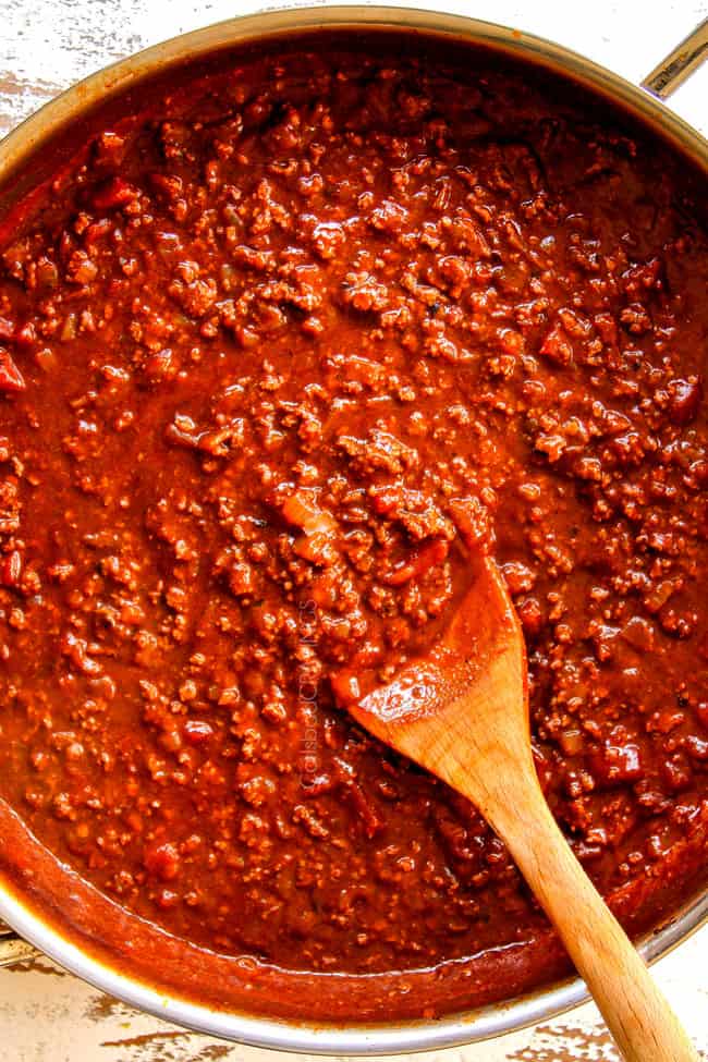 showing how to make Mexican Lasagna by simmering beef and homemade enchilada sauce until thickened