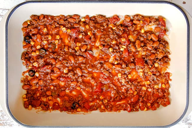 showing how to make Mexican Lasagna by layering the bottom of a 9x13 baking dish with 1 ½ cups of meat sauce