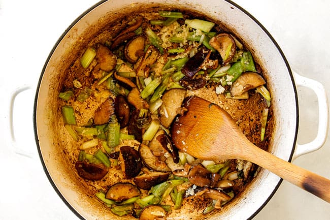 showing how to make ramen by sauteeing garlic, ginger and green onions